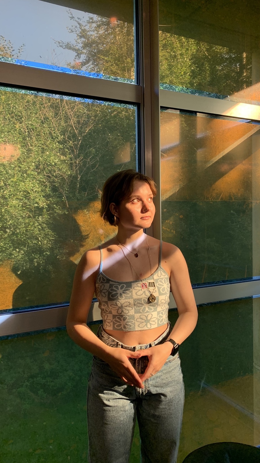 Alina by a big window, warm evening light falling across her